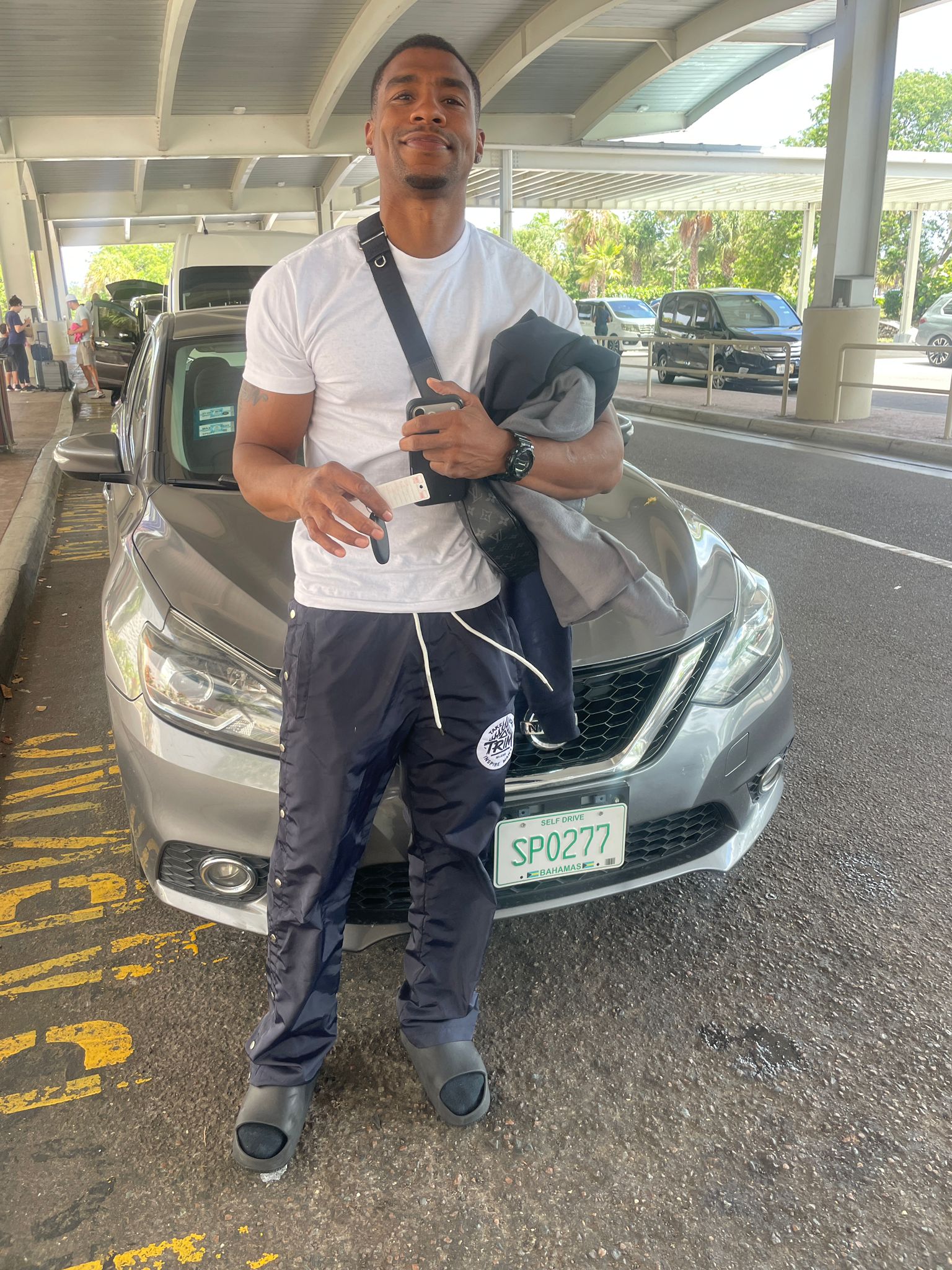 D'Luxe Rentals customer couple at the airport with rental car